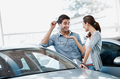 Buy stock photo Happy, couple and purchase in car dealership with keys, transport investment and motor insurance. Married people, shopping together and customer buy new vehicle in store with smile, promo and sale.