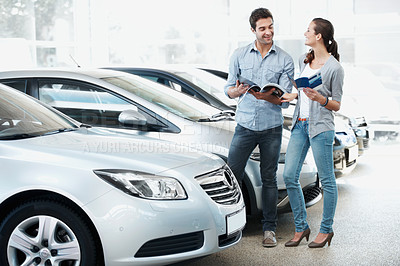 Buy stock photo Inspection, car or couple at dealership with book, selection or automobile catalog in showroom. Happy, relationship or people with leaflet, review together or purchase guide in vehicle evaluation.