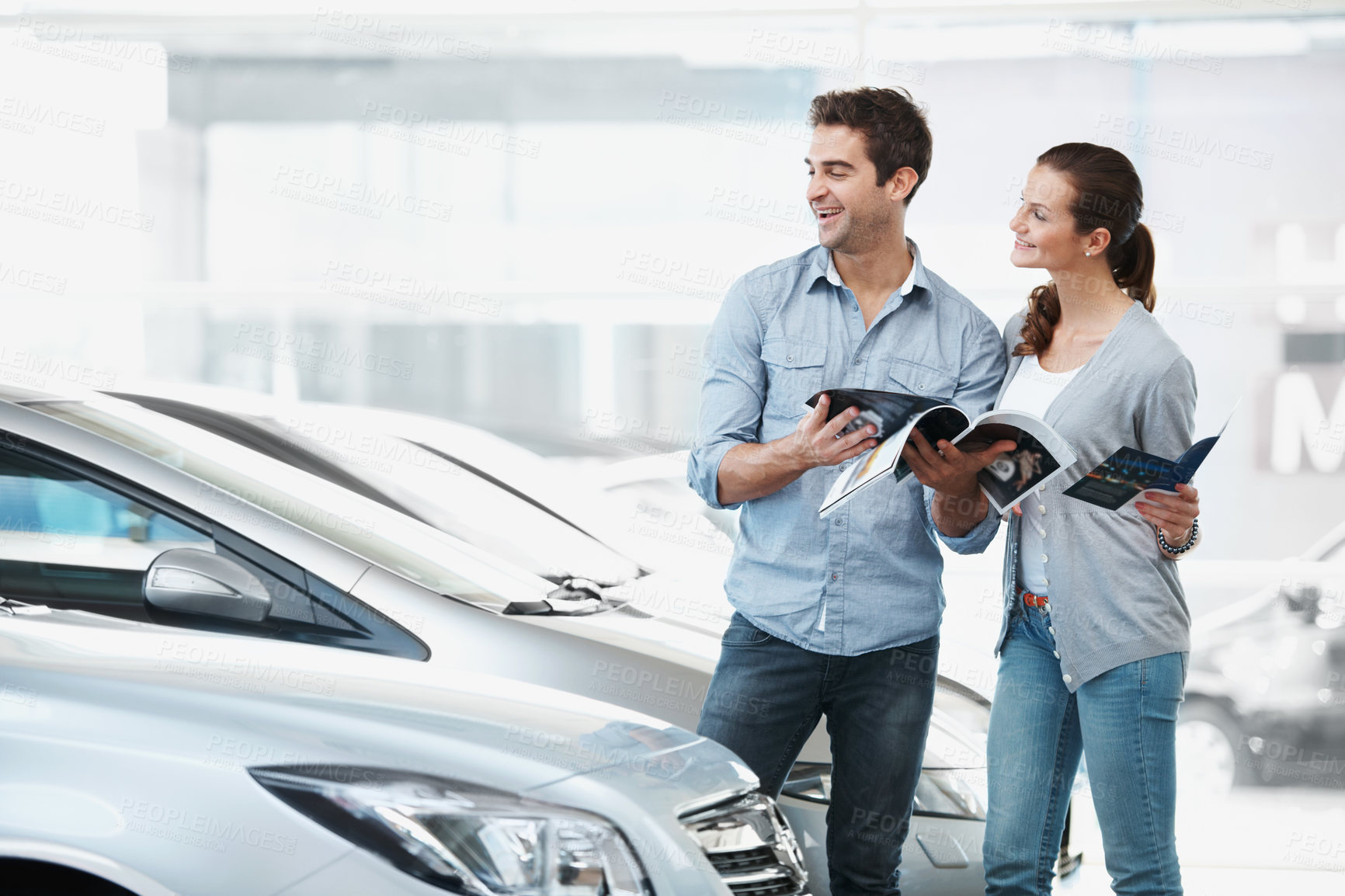 Buy stock photo Selection, car or couple at dealership with pamphlet, inspection or automobile review in showroom. Smile, relationship or people with brochure, choice together or purchase guide in vehicle evaluation