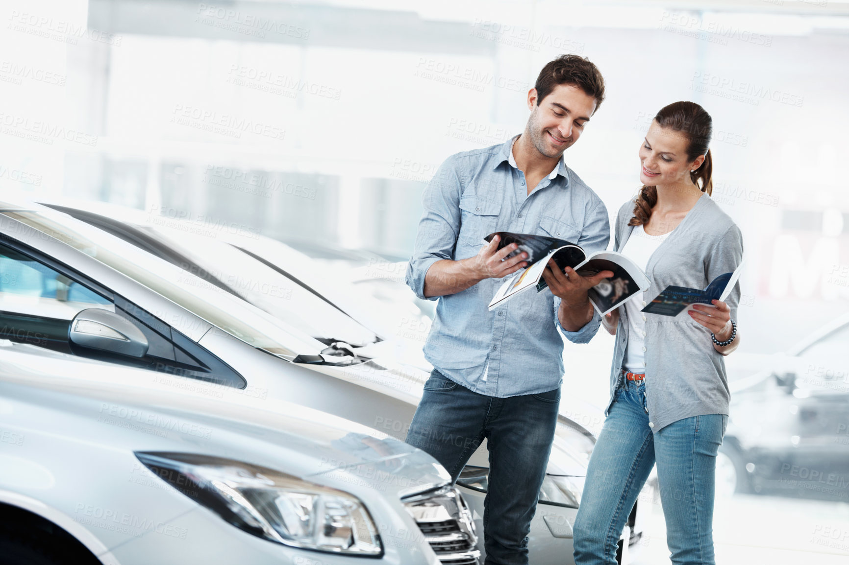 Buy stock photo Review, car or couple at dealership with pamphlet, selection or automobile catalog in showroom. Happy, relationship or people with leaflet, inspection together or purchase info in vehicle evaluation.