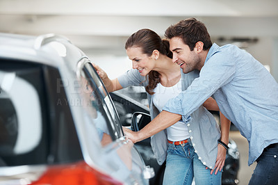 Buy stock photo Happy, car or couple at dealership with inspection, decision or automobile selection in showroom. Smile, relationship or people with choice, review together or purchase option with vehicle evaluation