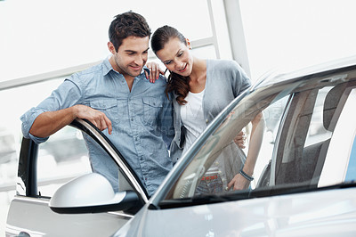 Buy stock photo Smile, couple and inspection at dealership with car, features and transport for test drive. Happy, people or quality control in showroom with vehicle, finance approval and collection of auto purchase