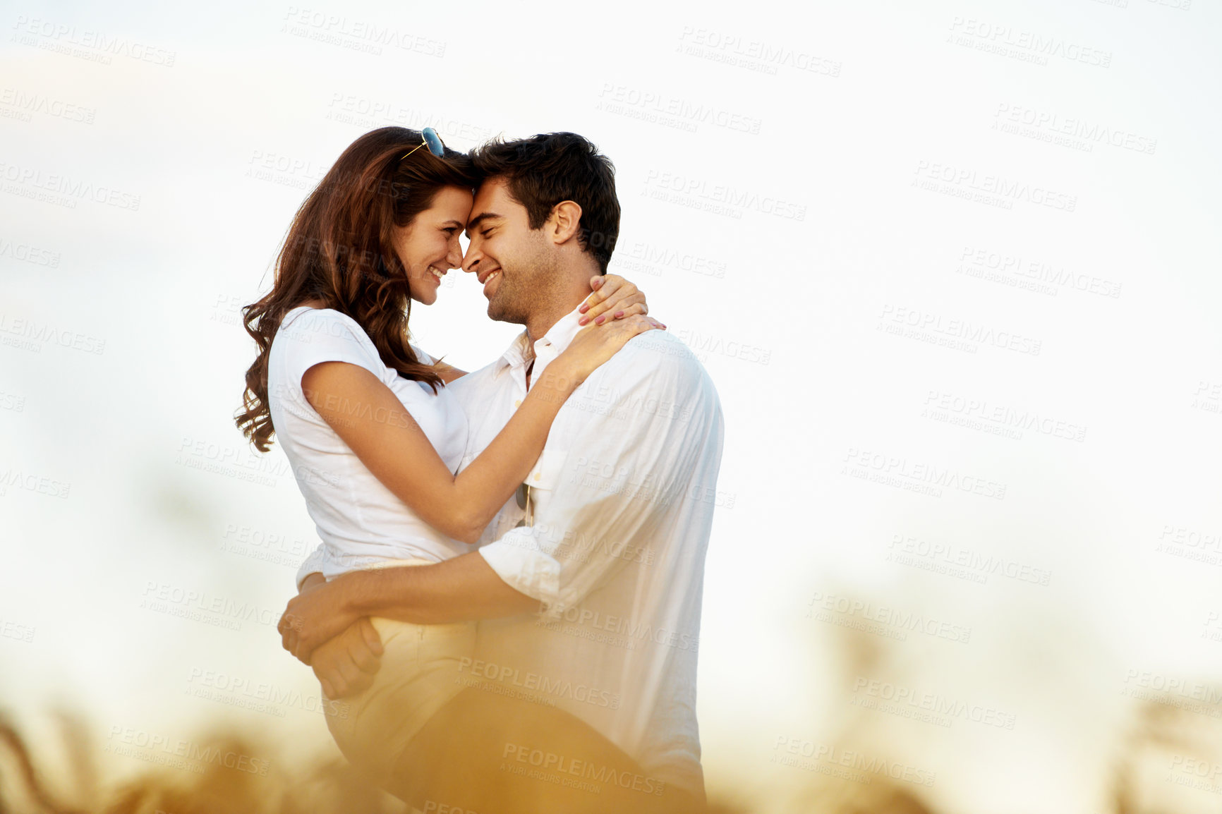 Buy stock photo Travel, couple and happy with hug in nature for romantic getaway, holiday connection and trust. Forehead touch, people and love embrace in field for anniversary trip, bonding or relationship on space