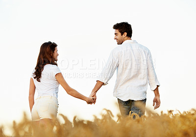 Buy stock photo Couple, holding hands and love with walking outdoor, partner and support with care in nature. People, marriage and romantic stroll in meadow for healthy relationship, bonding and together with trust