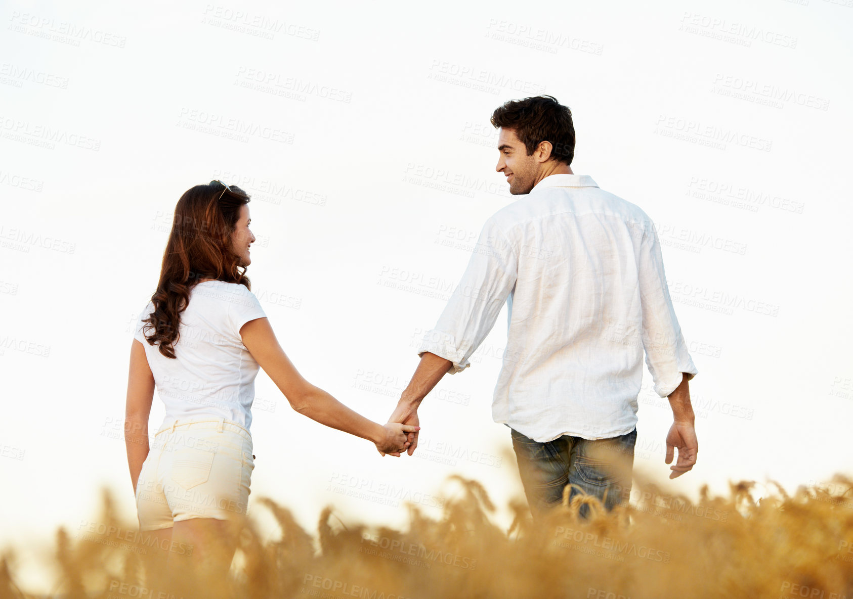 Buy stock photo Couple, holding hands and love with walking outdoor, partner and support with care in nature. People, marriage and romantic stroll in meadow for healthy relationship, bonding and together with trust