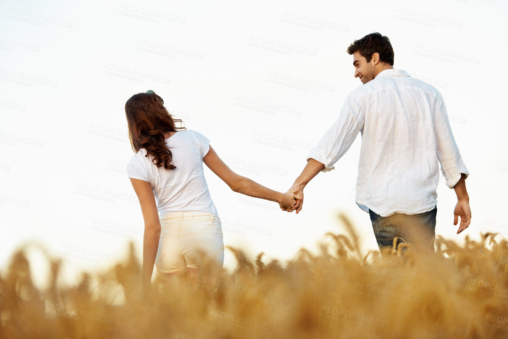 Buy stock photo Couple, holding hands and love with walk in meadow, partner and support with care in nature. People, marriage and romantic stroll outdoor for healthy relationship, bonding and together with trust