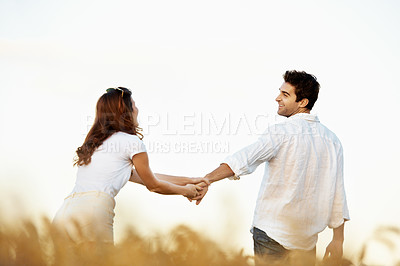 Buy stock photo Couple, happiness and man holding hands in meadow, partner and support with care in nature. Male person, smile and woman outdoor for relationship, bonding and together with love, space and walk