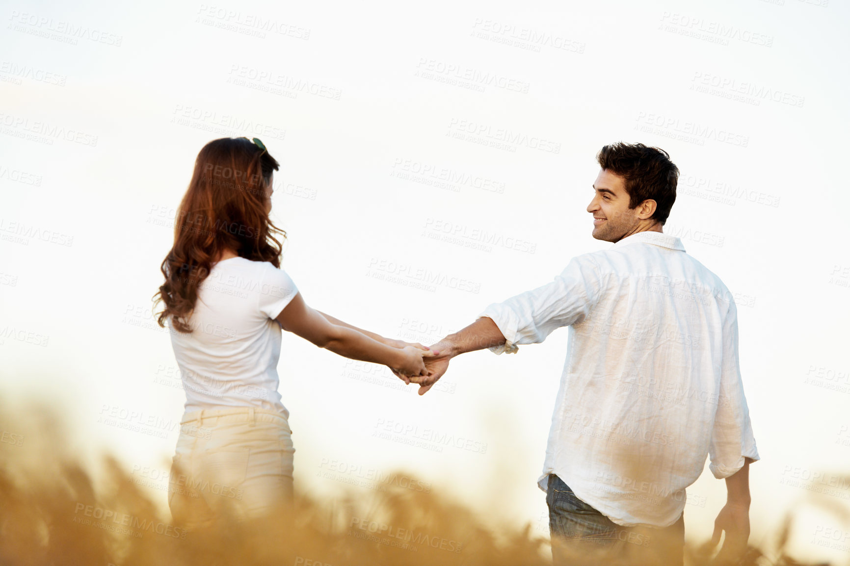 Buy stock photo Couple, holding hands and walking outdoor in meadow, partner and support with care in nature. People, marriage and romantic stroll for healthy relationship, bonding and together with space for love
