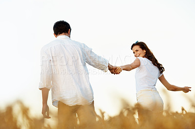Buy stock photo Couple, holding hands and outdoor in meadow on date, partner and support with care in nature. People, marriage and romantic stroll for healthy relationship, bonding and together with smile for love