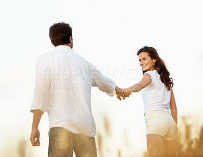 Buy stock photo Couple, happiness and woman holding hands in meadow, partner and support with care in nature. Female person, smile and man outdoor for healthy relationship, bonding and together with affection
