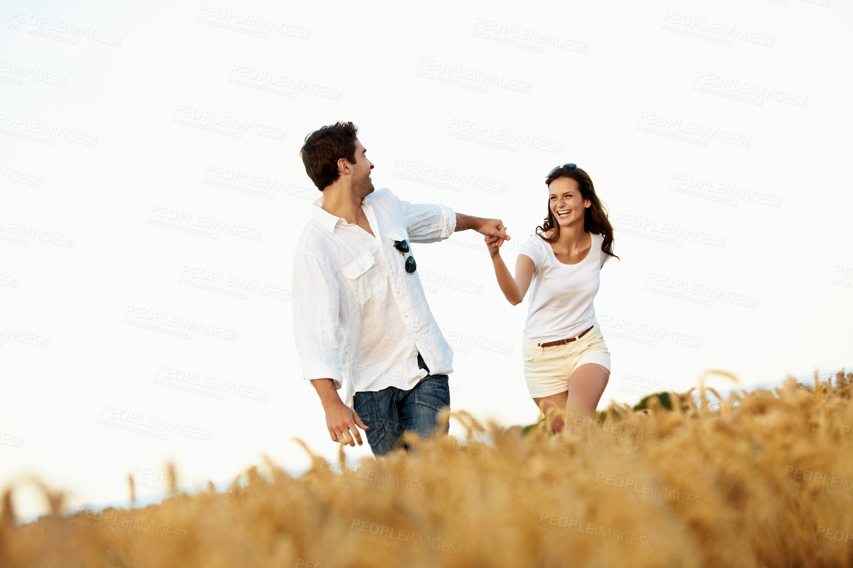 Buy stock photo Love, holding hands and couple in wheat field for bonding, vacation or romance in countryside. Happy, man and woman in nature for weekend trip together with holiday, anniversary and playful travel