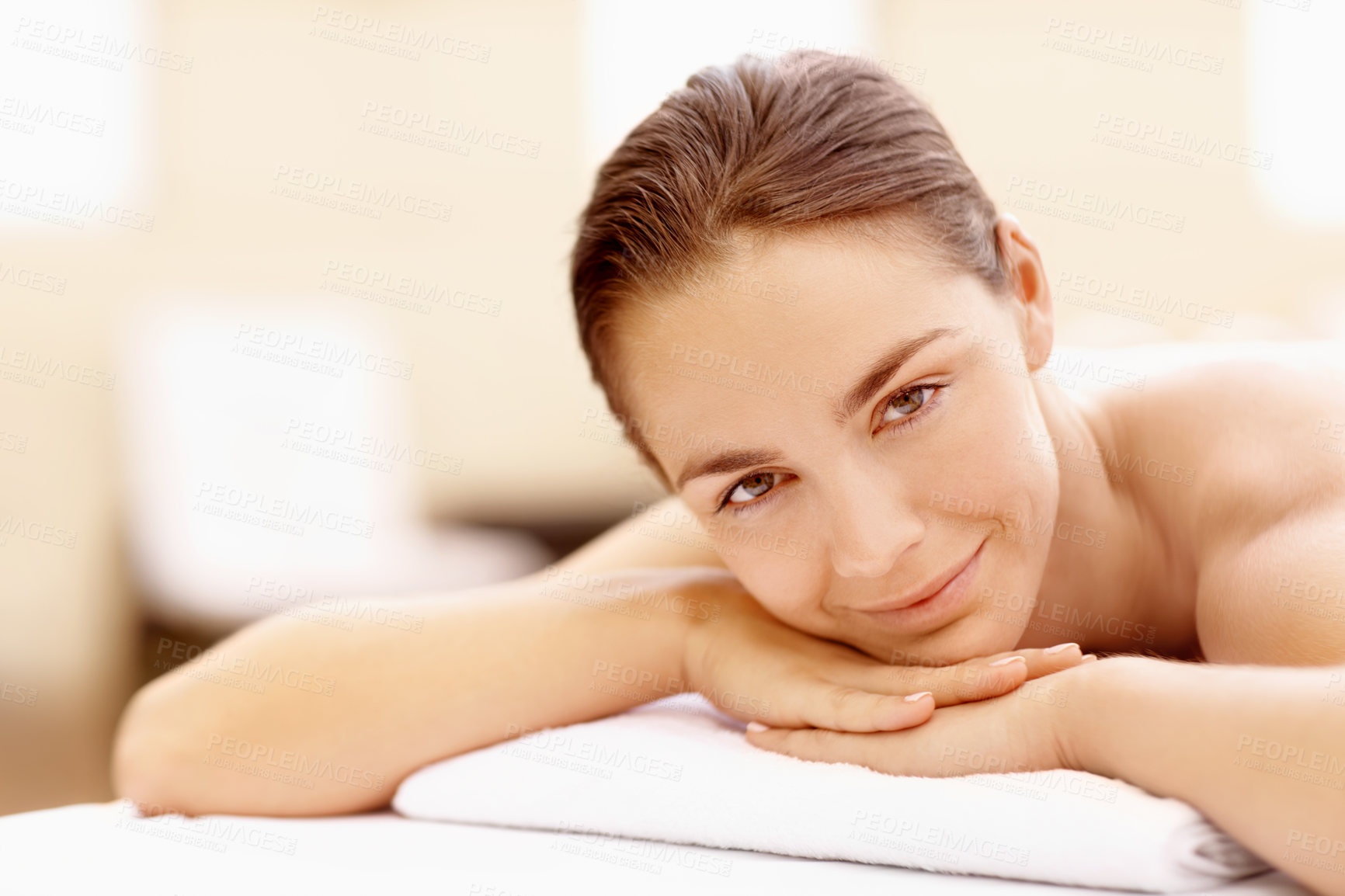 Buy stock photo Calm, portrait and massage table with woman in spa for skincare treatment, wellness and body care. Zen, beauty salon and hospitality with person in hotel resort for lodge, smile and detox therapy