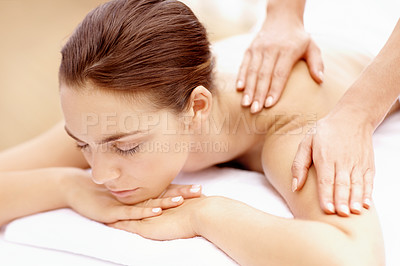 Buy stock photo Rested young woman lying on a spa bed with her eyes closed and receiving a massage
