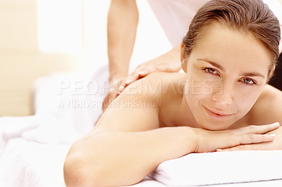 Buy stock photo Relaxed young woman lying on a spa bed and smiling while receiving a massage