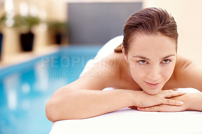 Buy stock photo Beautiful young woman lying on a spa bed with a pool in the background - portrait 
