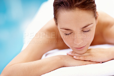 Buy stock photo Attractive young woman lying on a spa bed with a pool in the background - portrait 