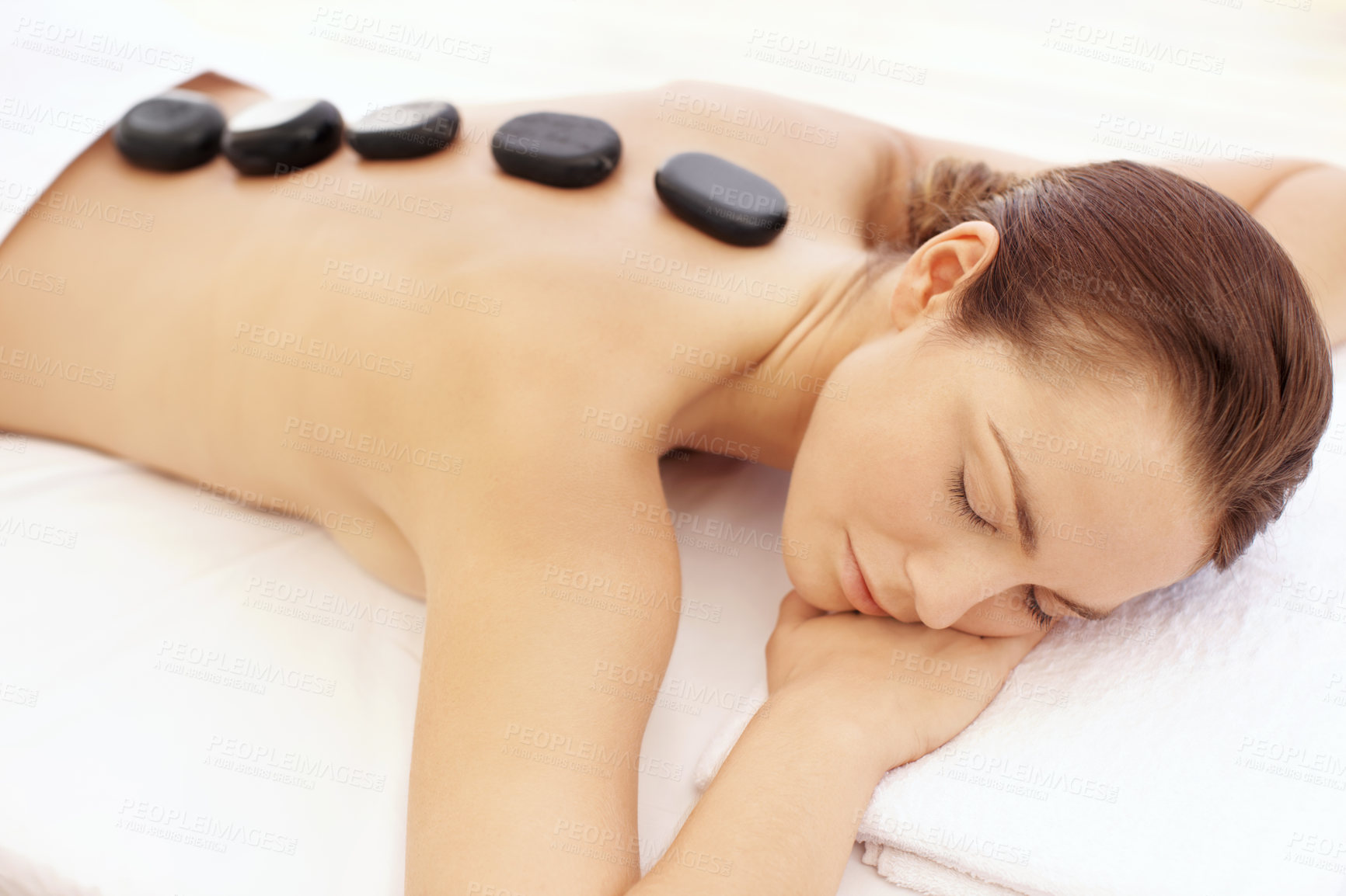 Buy stock photo Woman, spa and hot stone massage for self care, wellness and break with treatment for stress relief. Female person, luxury and warm rocks on back, bodycare and detox with calm or peace at resort