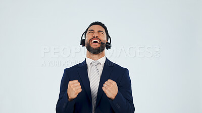 Buy stock photo Excited, man and fist pump in studio with headset, customer praise and success for sales kpi. Smile, mockup space and agent cheering for good news, technical support and help desk on white background
