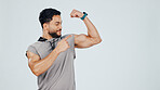 Man, pointing and flexing bicep for fitness, gym and pride in muscle with results or progress in studio. Personal trainer, strong or power with smile for exercise and bodybuilding on background space