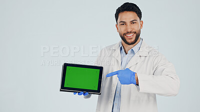 Buy stock photo Green screen, pointing and portrait of doctor with tablet in studio for clinic sign up, telehealth or FAQ. Technology, space and healthcare worker on app for medical information by white background.