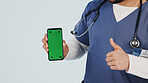Nurse, phone and thumbs up with green screen in studio for marketing app on a white background. Person, healthcare worker or hands showing mockup space with like emoji for advertising or good review