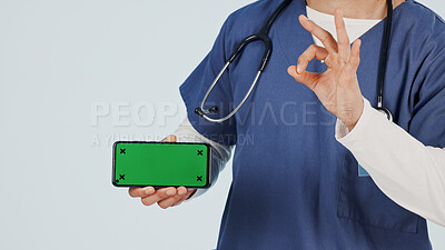 Buy stock photo Nurse, phone and hands with green screen for marketing app on a white studio background. Person, healthcare worker or showing mockup space with like emoji or OK sign for advertising or good review