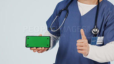 Buy stock photo Nurse, phone and thumbs up with green screen in studio for advertising or Telehealth app. Person, hands or healthcare worker with like emoji or technology mockup for marketing on a white background