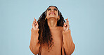 Excited, woman and hope in studio with fingers crossed, good luck and anticipation for lottery. Female person, pray and happy expression with hand gesture, competition and results on blue background
