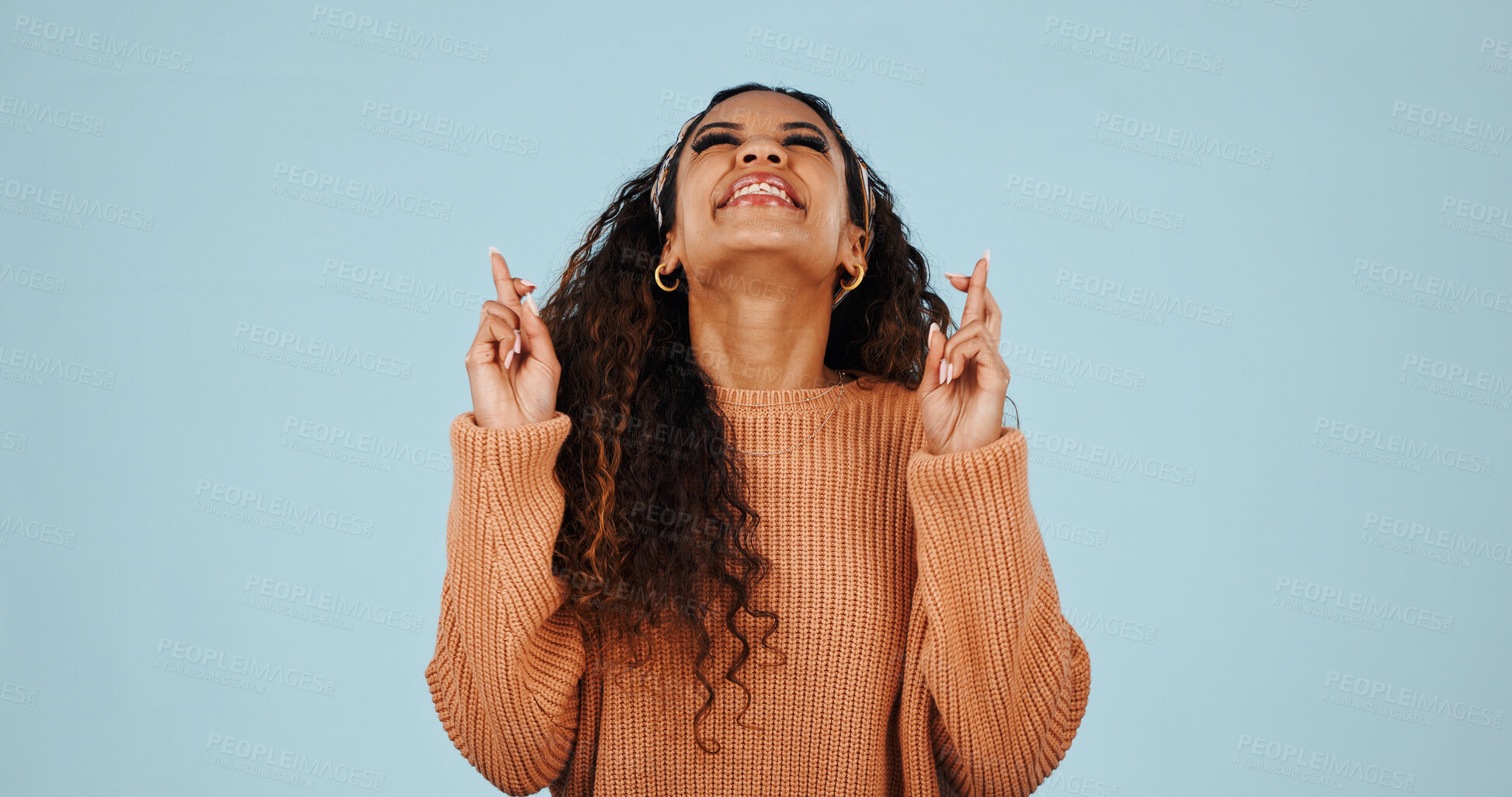 Buy stock photo Excited, woman and hope in studio with fingers crossed, good luck and anticipation for lottery. Female person, pray and happy expression with hand gesture, competition and results on blue background