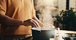 Cooking, steam and man in kitchen with pot, recipe and meal prep for dinner, lunch or supper. Home, hands and person by stove with ingredients, boiling and heat for nutrition, health and cuisine
