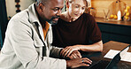 Mature, couple and holding hands in home with laptop, online website and review insurance premium. People, interracial marriage and reading in house with computer, policy cover terms and conditions.