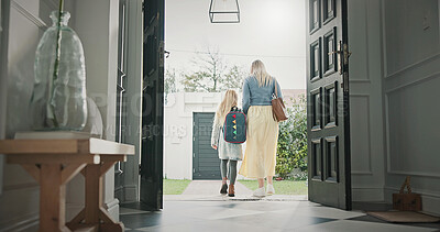 Buy stock photo Mother, leaving and girl in home with backpack, support and back to school for education. Woman, walking or front door with daughter for commute, morning routine and bonding together for learning