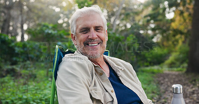 Buy stock photo Nature, portrait and senior man on camping chair with smile, relax and outdoor for adventure trip. Bokeh, happy old person and chill in peaceful forest with wellness, travel vacation or weekend break