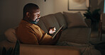 Tablet, relax and black man in home at night for reading blog on budget, savings and investment planning. Digital technology, scrolling and mature person on app for financial tips, advice or guidance
