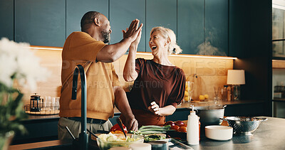Buy stock photo Cooking, high five and laughing with interracial couple in kitchen of home together for meal preparation. Bonding, having fun and success with mature people in apartment for culinary goals or target
