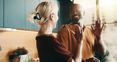 Buy stock photo Cooking, high five and smile with interracial couple in kitchen of home together for meal preparation. Bonding, love and success with mature people in apartment for culinary goals, hobby or target