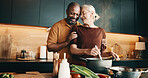 Cooking, hug and smile with interracial couple in kitchen of home together for meal preparation. Bonding, love and security with mature people in apartment for culinary hobby, food or wellness