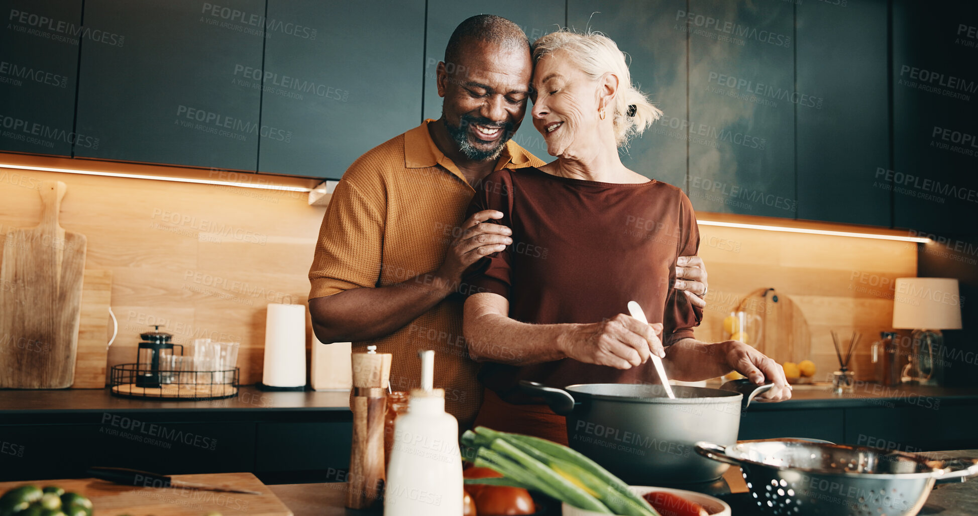 Buy stock photo Cooking, hug and smile with interracial couple in kitchen of home together for meal preparation. Bonding, love and security with mature people in apartment for culinary hobby, food or wellness