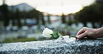 Hand, tombstone and rose in graveyard with funeral, remembrance and burial ceremony for final goodbye. Space, flower and person in cemetery outdoor with gravestone, memorial service and mourning.