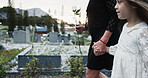 Holding hands, mother and girl in graveyard, sad and emotions for grief, bereavement and loss. Family, parent and daughter with support for funeral, people or burial for death, comfort or compassion