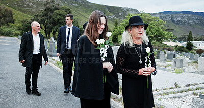 Buy stock photo People, sad and flowers in graveyard, support for funeral and mourning for loss. Cemetery, women and family with compassion, grief and burial for death ceremony, memorial service and remembrance