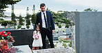Father, child and hug in graveyard with tombstone, funeral support and burial ceremony for family. Man, daughter and embrace in cemetery outdoor with sympathy, compassion and gravestone for memorial.