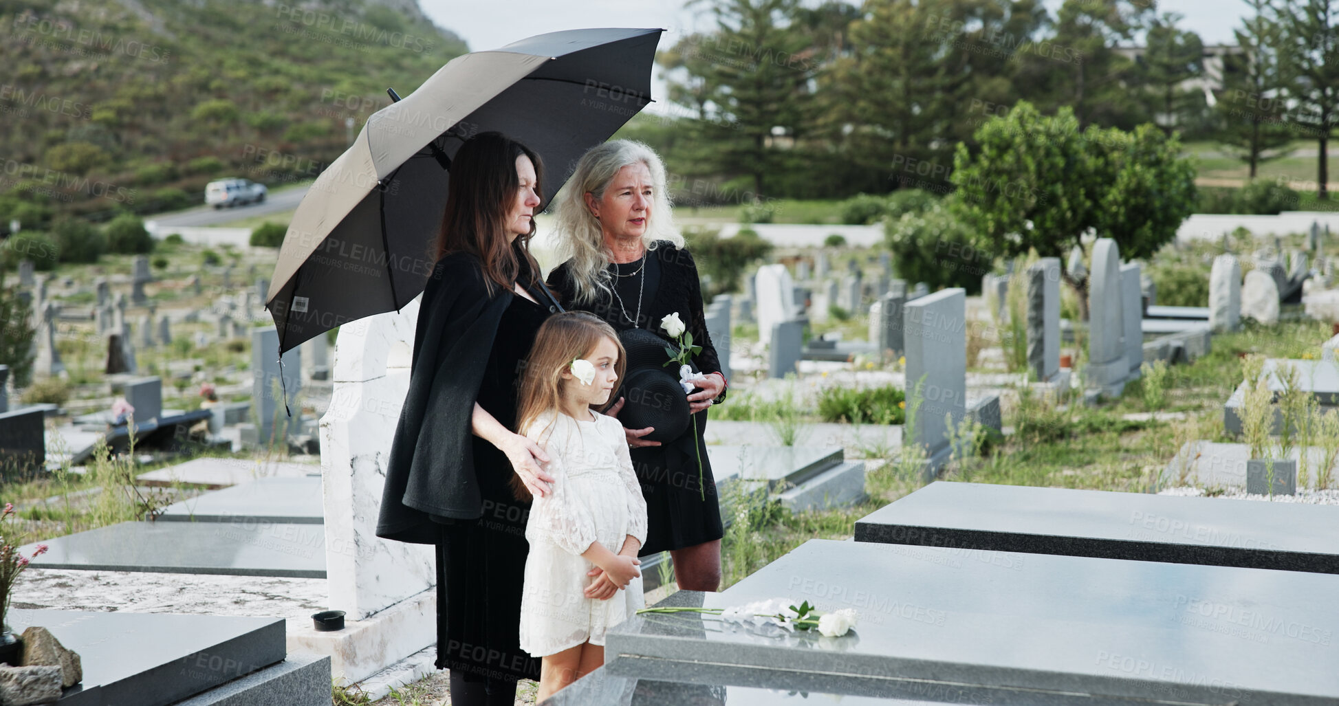 Buy stock photo Family, funeral and rose with respect in cemetery for grief or mourning death together in graveyard. Women, child and empathy with flowers or offering for farewell, burial or ceremony on tombstone