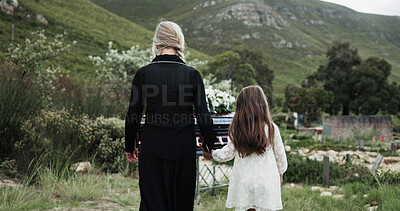 Buy stock photo Holding hands, mother and girl in graveyard, back and emotions for grief, compassion and loss. Family, parent and daughter with support for funeral, people or cemetery for burial, comfort or empathy