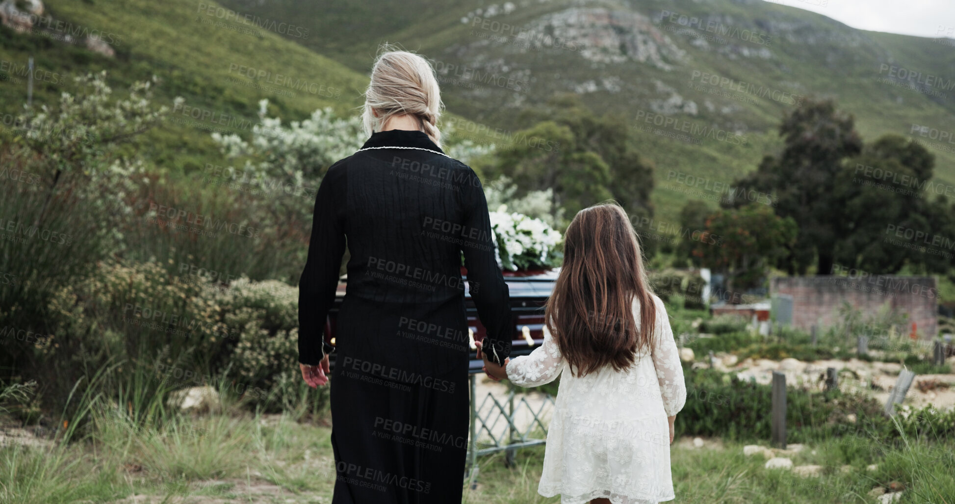 Buy stock photo Holding hands, mother and girl in graveyard, back and emotions for grief, compassion and loss. Family, parent and daughter with support for funeral, people or cemetery for burial, comfort or empathy
