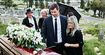 Casket, comfort and family in cemetery, funeral for memorial service or flower bouquet. People, sad or burial ceremony in graveyard, roses or emotion to grief, loss or greeting with empathy or coffin