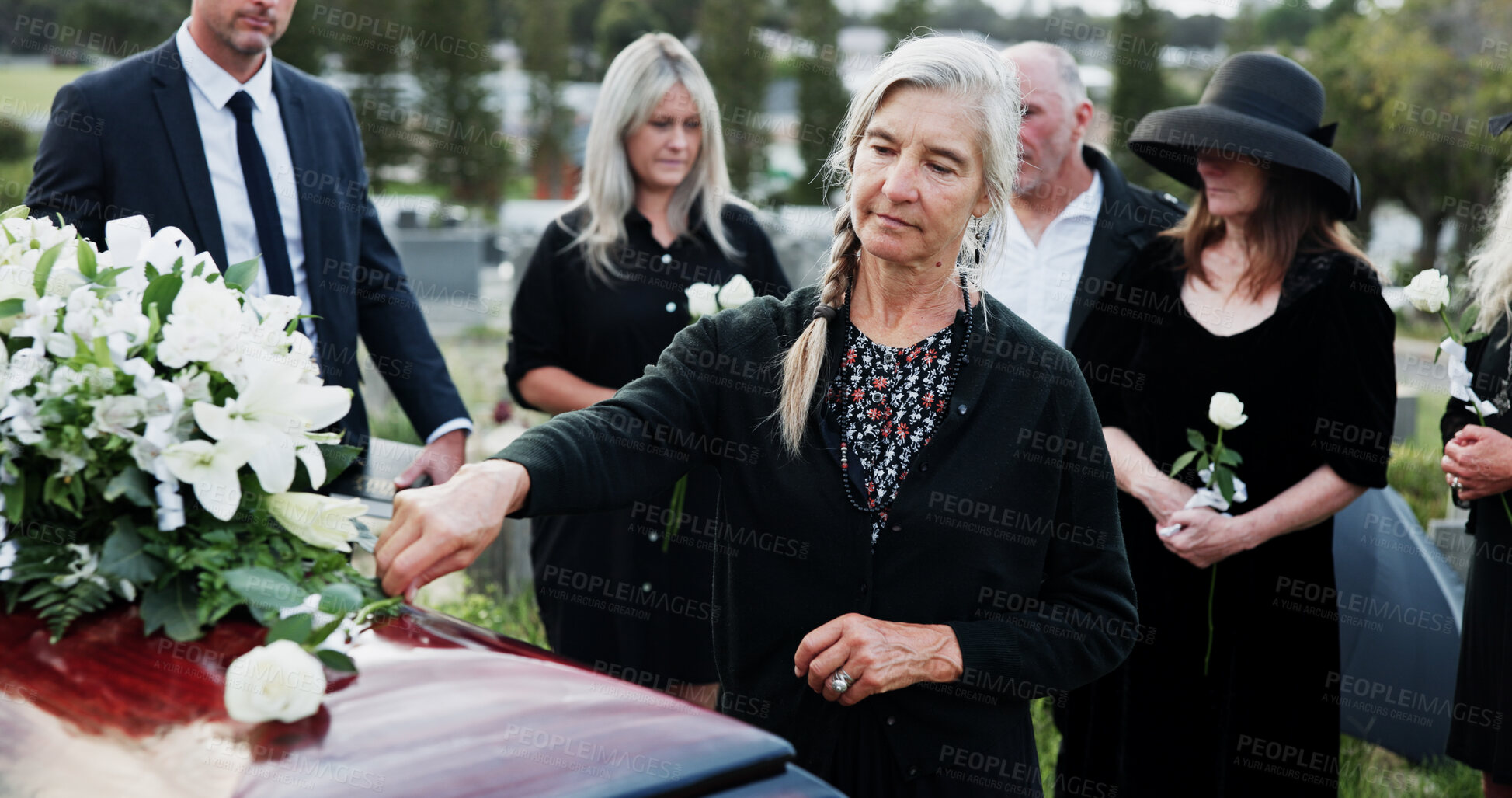 Buy stock photo Woman funeral and rose with offering on coffin for grief or mourning death together in graveyard. Female person, family and empathy with flower for farewell, burial or paying respect in cemetery