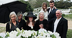 Sad, people and funeral in graveyard with flowers, support or grief for burial ceremony of loved one. Family, death and mourning in cemetery outdoor with white rose, bereavement and memorial service.