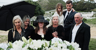 Buy stock photo Sad, people and funeral in graveyard with flowers, support or grief for burial ceremony of loved one. Family, death and mourning in cemetery outdoor with white rose, bereavement and memorial service.