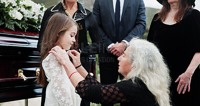 Buy stock photo Sad, grandmother and child in graveyard with funeral, people mourning and support for burial ceremony. Senior woman, girl and family death at cemetery outdoor with memorial service, empathy and care.